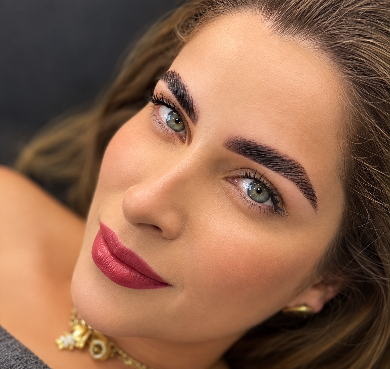 Cliente com maquiagem e sobrancelhas alinhadas e volumosas após brow lamination
